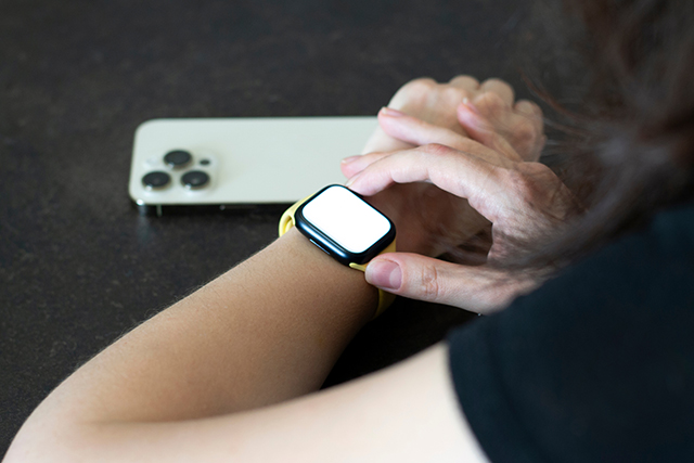 Apple Watchのボタンを押している写真。