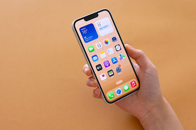 iPhone 16eを片手で操作する様子｜自宅ソファでの取り回しイメージ