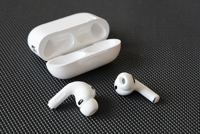 白いAirPods Pro 3本体とケースをテーブルに平置き。開閉部や通気口の位置が分かり、作りの丁寧さが伝わる。