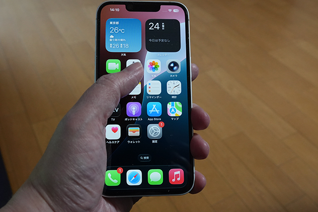 片手でiPhone 16eを持ち、親指が画面上方へ。